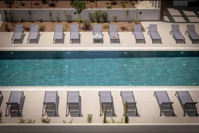 an overhead view of chairs and a swimming pool at Kalamon Luxury Suite 202 w Pool and Gym in Larnaka