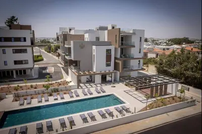 an aerial view of a building with a swimming pool at Kalamon Luxury Suite 202 w Pool and Gym in Larnaka