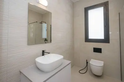 a white bathroom with a sink and a toilet at Kalamon Luxury Suite 202 w Pool and Gym in Larnaka