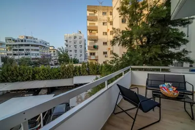 a balcony with two chairs and a table at Boutique & Brand New Prime Location Park & Beach in Limassol