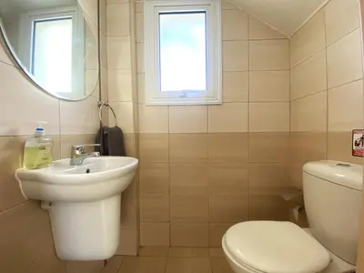 a bathroom with a toilet and a sink and a mirror at Artemis Holiday Villa DPS09 with pool in Paralimni