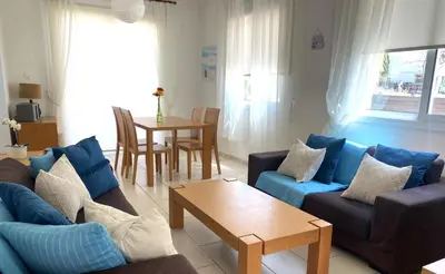 a living room with blue couches and a table at Artemis Holiday Villa DPS09 with pool in Paralimni