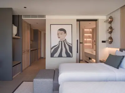 a bedroom with two beds and a painting on the wall at kolektif suites in Kérynia