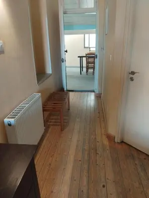 a hallway with a wooden floor and a room with a table at PAOK Kakopetria in Aglantzia