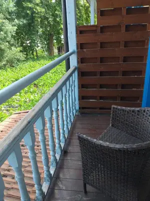 a wicker chair sitting on a wooden porch at PAOK Kakopetria in Aglantzia