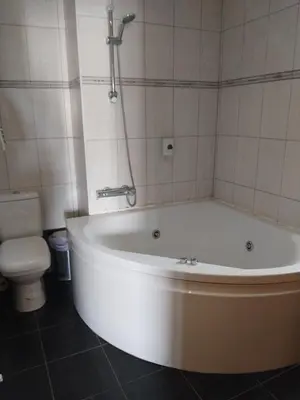 a white bath tub in a bathroom with a toilet at PAOK Kakopetria in Aglantzia