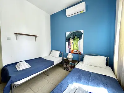 two beds in a room with blue walls at STAY Thalassa Villa in Paralimni