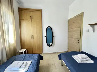 a bedroom with a blue bed and a mirror at STAY Thalassa Villa in Paralimni
