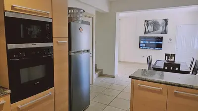 a kitchen with a stainless steel refrigerator and a table at STAY Nissi House in Ayia Napa