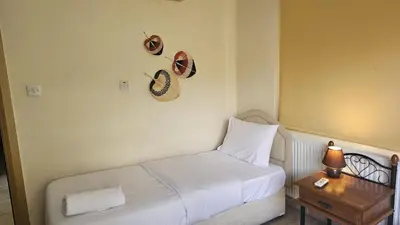a room with a bed and a table with a hat at STAY Nissi House in Ayia Napa