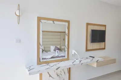 a mirror on a wall next to a bed at Tsokkos Protaras Beach Hotel in Protaras