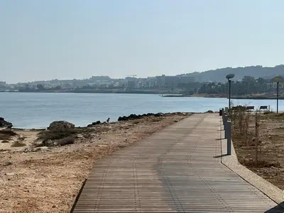 a boardwalk on a beach next to a body of water at Tsokkos Protaras Beach Hotel in Protaras