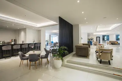 a lobby with tables and chairs and a bar at Tsokkos Protaras Beach Hotel in Protaras