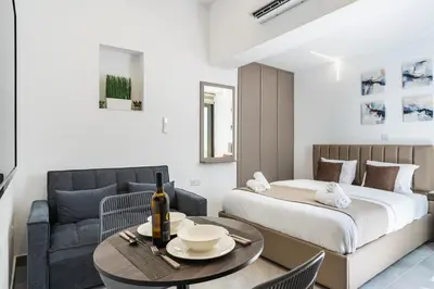 a bedroom with a bed and a table and a couch at Starlight Studio in Larnaka