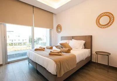 a bedroom with a bed with towels on it at Nissinest Luxury Villas in Ayia Napa