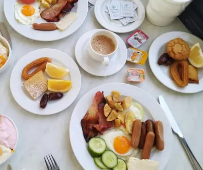 a table with plates of breakfast food and a cup of coffee at Nelia Sea Breeze in Ayia Napa