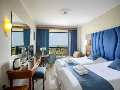 a hotel room with two beds and a desk at Anastasia Waterpark Beach Resort in Protaras