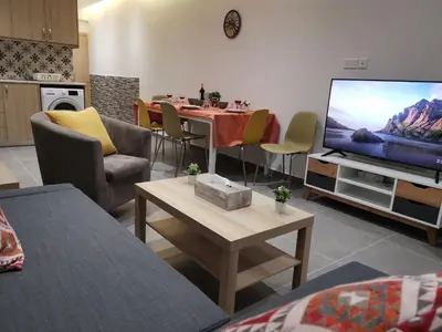 a living room with a table and a television at Martins 3 Bedroom Flat in Larnaka