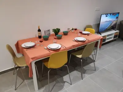 a dining room table with chairs and a bottle of wine at Martins 3 Bedroom Flat in Larnaka