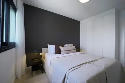 a bedroom with a large bed and a black wall at Rooftop Sunset Garden by Staycom in Pamboula