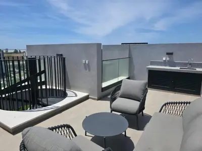 a patio with chairs and a table and a sink at Rooftop Sunset Garden by Staycom in Pamboula