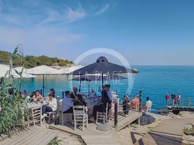 a group of people sitting at a table on the beach at Cosy 2Br Family Apartment - Mythical Sands Resort in Paralimni