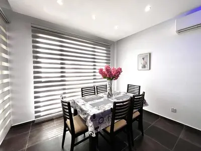 a dining room with a table with a vase of flowers at STAY NEO Coast Apartment in Limassol