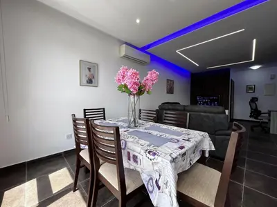 a dining room table with a vase of flowers on it at STAY NEO Coast Apartment in Limassol