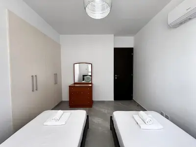 two beds in a room with a mirror at STAY NEO Coast Apartment in Limassol