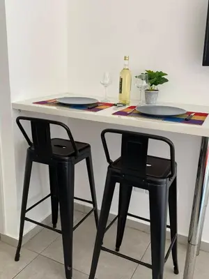 a table with two chairs and two plates and a bottle of wine at Mangoes & Cherries in Ayia Napa