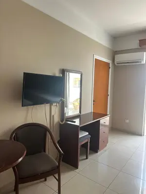 a living room with a desk with a chair and a mirror at Ellis Hotel Apartments in Larnaka