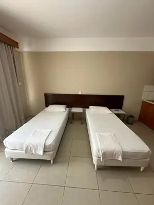 two beds sitting in a room with at Ellis Hotel Apartments in Larnaka