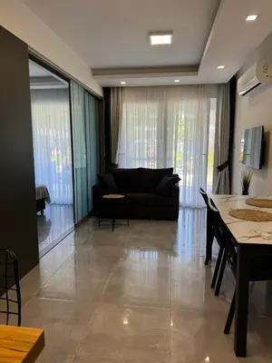 a living room with a couch and a table at Wakacyjny apartament w Courtyard Long Beach Holiday Resort in Iskele