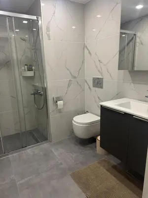 a bathroom with a shower and a toilet and a sink at Wakacyjny apartament w Courtyard Long Beach Holiday Resort in Iskele