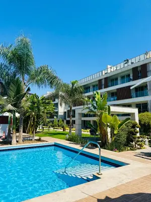 a swimming pool in front of a building at Wakacyjny apartament w Courtyard Long Beach Holiday Resort in Iskele
