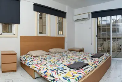 a bedroom with a large bed with a colorful comforter at Martin 2 bed Apartment in Larnaka