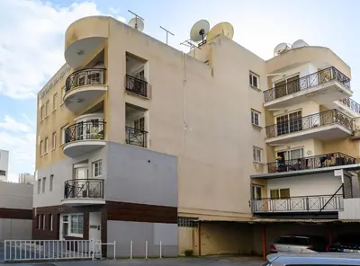 a building with balconies and cars parked in front of it at Martin 2 bed Apartment in Larnaka