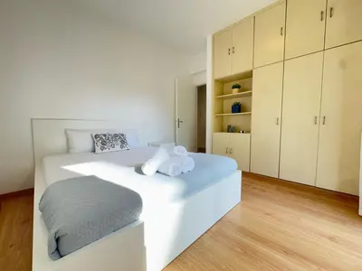 a white bedroom with a large white bed and cabinets at Stasandrou City Center Residence in Nicosia