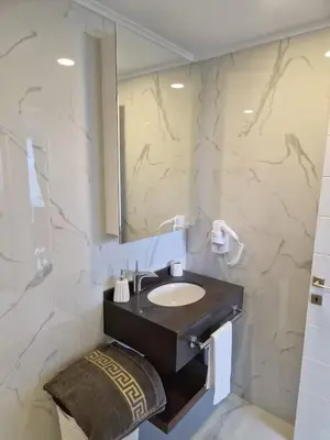 a bathroom with a sink and a mirror at Grand Sapphire Resort & Casino in Phikardhou