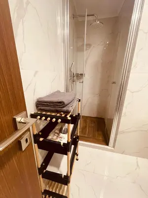 a bathroom with a shower and a towel on a rack at Grand Sapphire Resort & Casino in Phikardhou