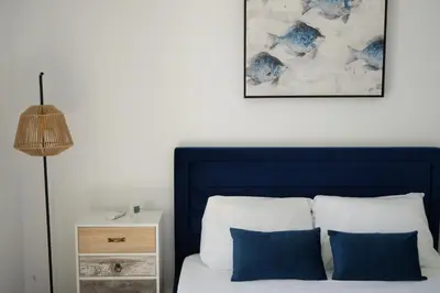 a bedroom with a blue headboard and a bed with pillows at Nomad's Nest - Quiet flat with terrace in Ayia Napa
