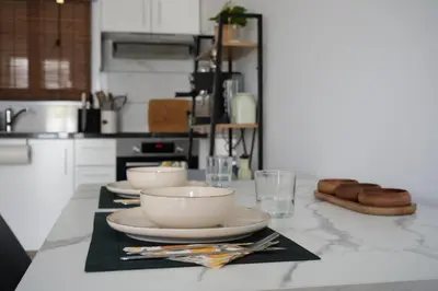 a kitchen with three bowls and plates on a counter at Nomad's Nest - Quiet flat with terrace in Ayia Napa