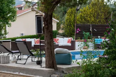 a backyard with a pool and a table and chairs at Villa Althea, Pool, Mountain Views, BBQ ,Patio in Laneia in Lania