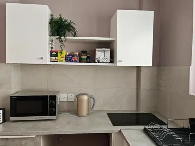 a kitchen with white cabinets and a microwave at Studio in the center of Nicosia 3 in Nicosia