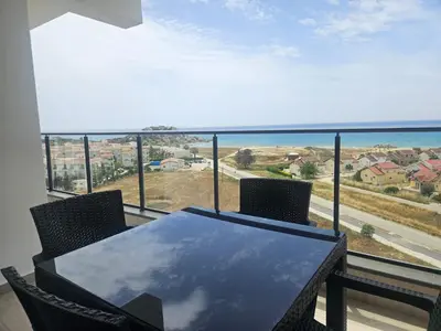 a table and chairs on a balcony with a view of the ocean at Seaview Apartment at Caesar Blue Complex Northern Cyprus H68 in Dherinia