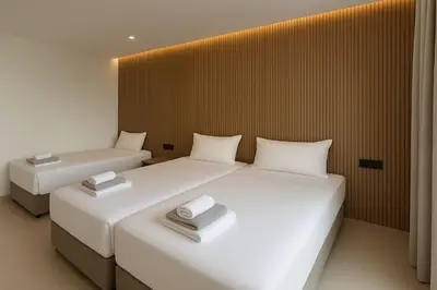 two beds in a room with two towels on them at NÓA Rooms - Adults Only in Ayia Napa