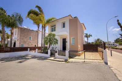 a house with a gate and palm trees at Villa Parrog in Protaras