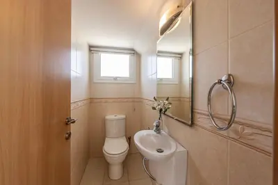 a bathroom with a toilet and a sink and a mirror at Villa Parrog in Protaras