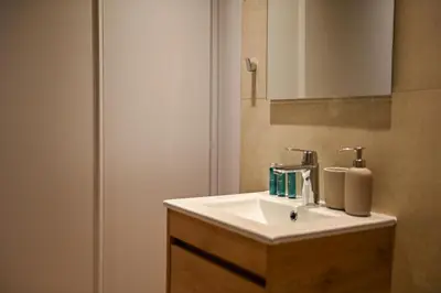 a bathroom with a white sink and a mirror at The 1 -Nicosia Elite Stay- Gym Pool 24h Concierge in Nicosia