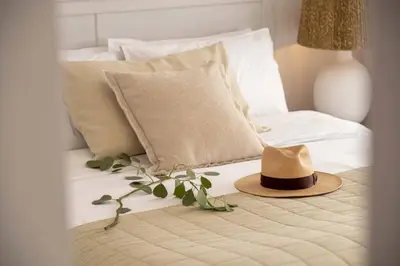a hat sitting on top of a bed with pillows at Sirena Solis Villa - Elegant 5-bedroom Sea View Retreat near Sirena Bay in Protaras
